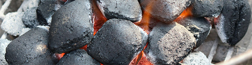 Varme grillkul med gløder og ild i en kulgrill.