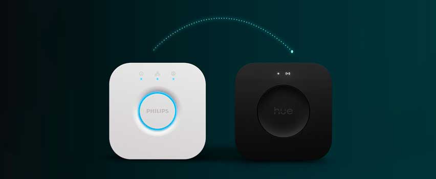 Philips Hue Bridge i hvid og sort med lysende indikatorer, forbundet med en stiplet pil som symbol på opsætning eller opgradering.