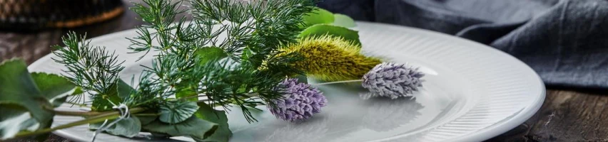 Hvid Pillivuyt Plissé tallerken med riflet kant pyntet med dild, eukalyptus og lilla purløgsblomster