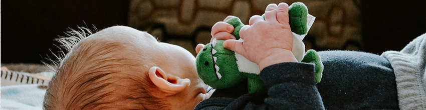 Baby dreng med tøjdyr i hænderne, gaveidé til drenge der inviterer til leg og tryghed.