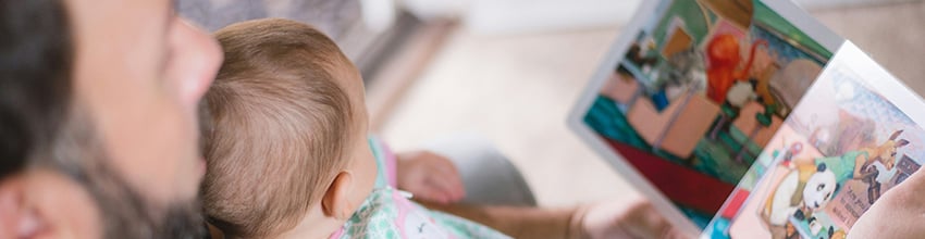 Far med baby på skødet læser højt, gaveidé der styrker nærvær og tid sammen for nybagte fædre.