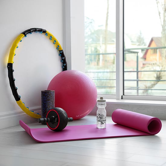 Wozinsky sport- og fitnessudstyr med pink yogamåtte, bold, hulahopring, skumrulle og drikkedunk ved vindue