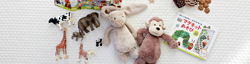 Baby sidder på tæppe fyldt med legetøj og bøger